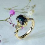 ブルートルマリンを中央に配し、サイバーパンク調の石座と植物モチーフの装飾が特徴のゴールド婚約指輪 OR-1868