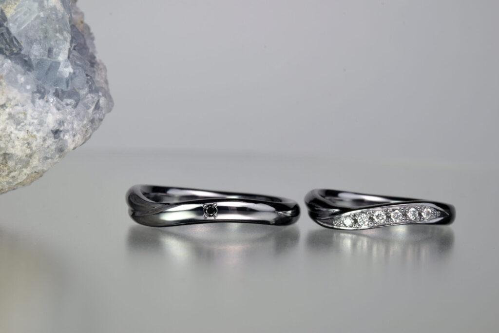 ブラックダイヤとメレダイヤを留めた流線形のタンタル結婚指輪