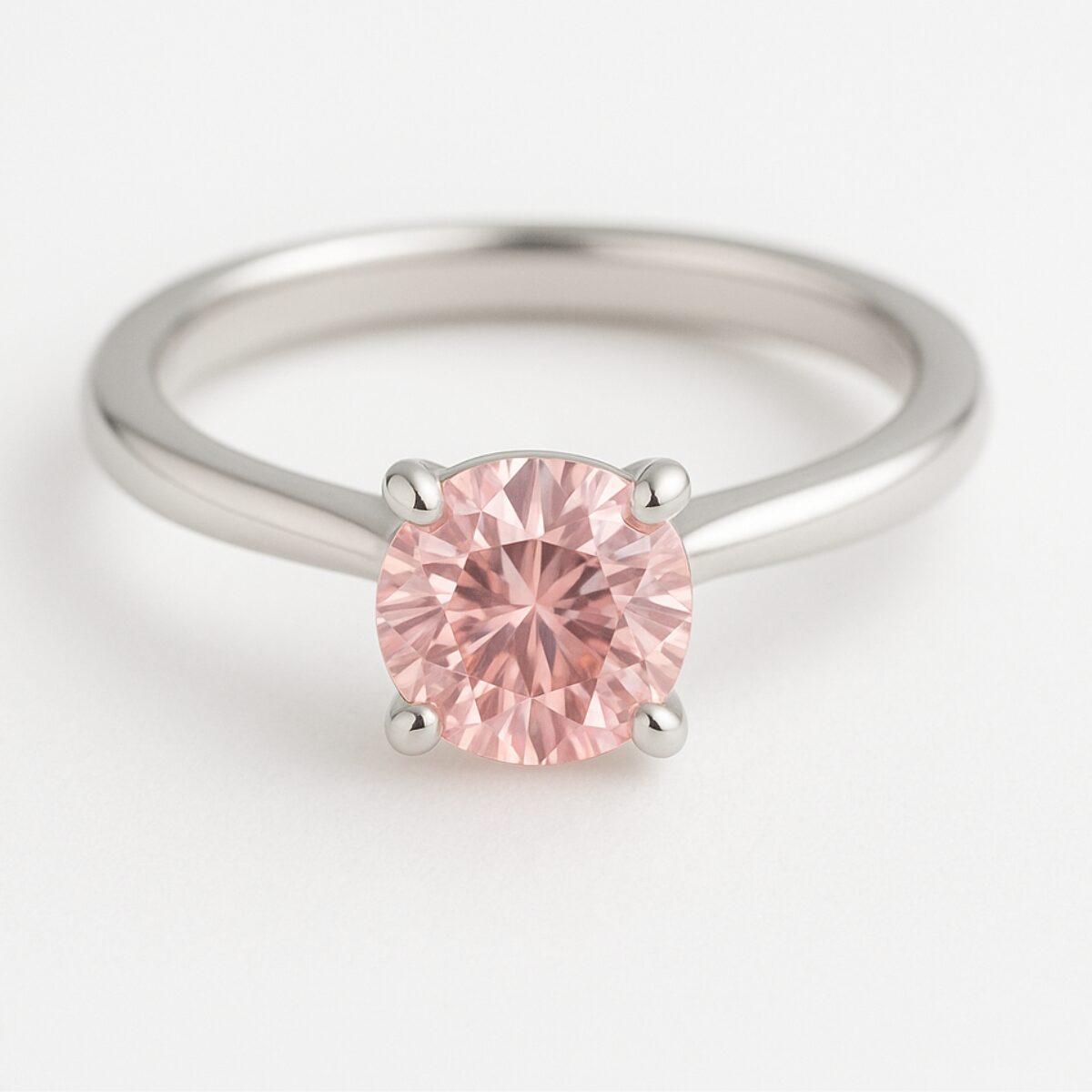 プラチナ色のリングにピンク色のラウンドストーンを留めた婚約指輪
