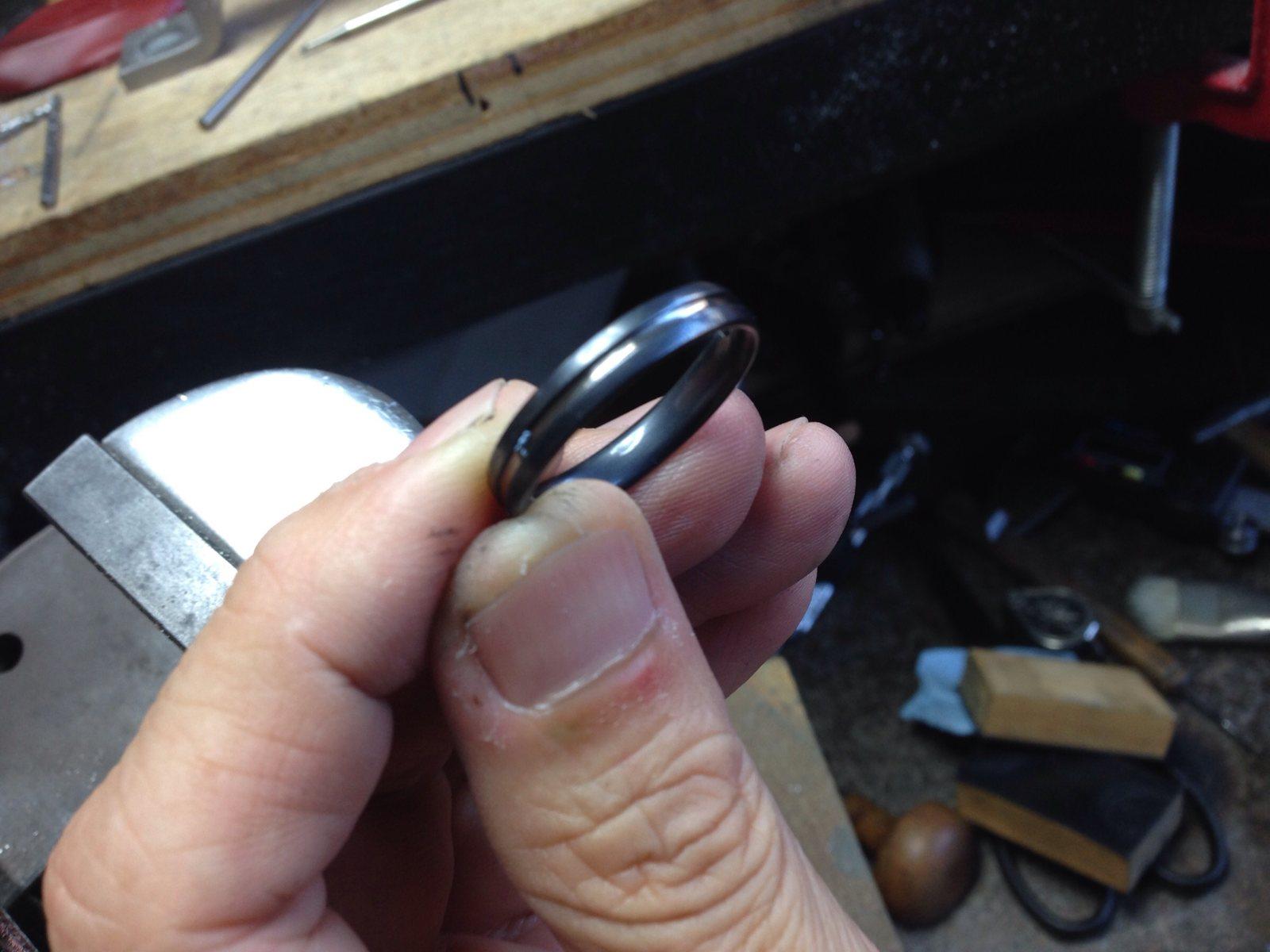 黒い結婚指輪を職人が丁寧に確認する手作業の制作シーン
