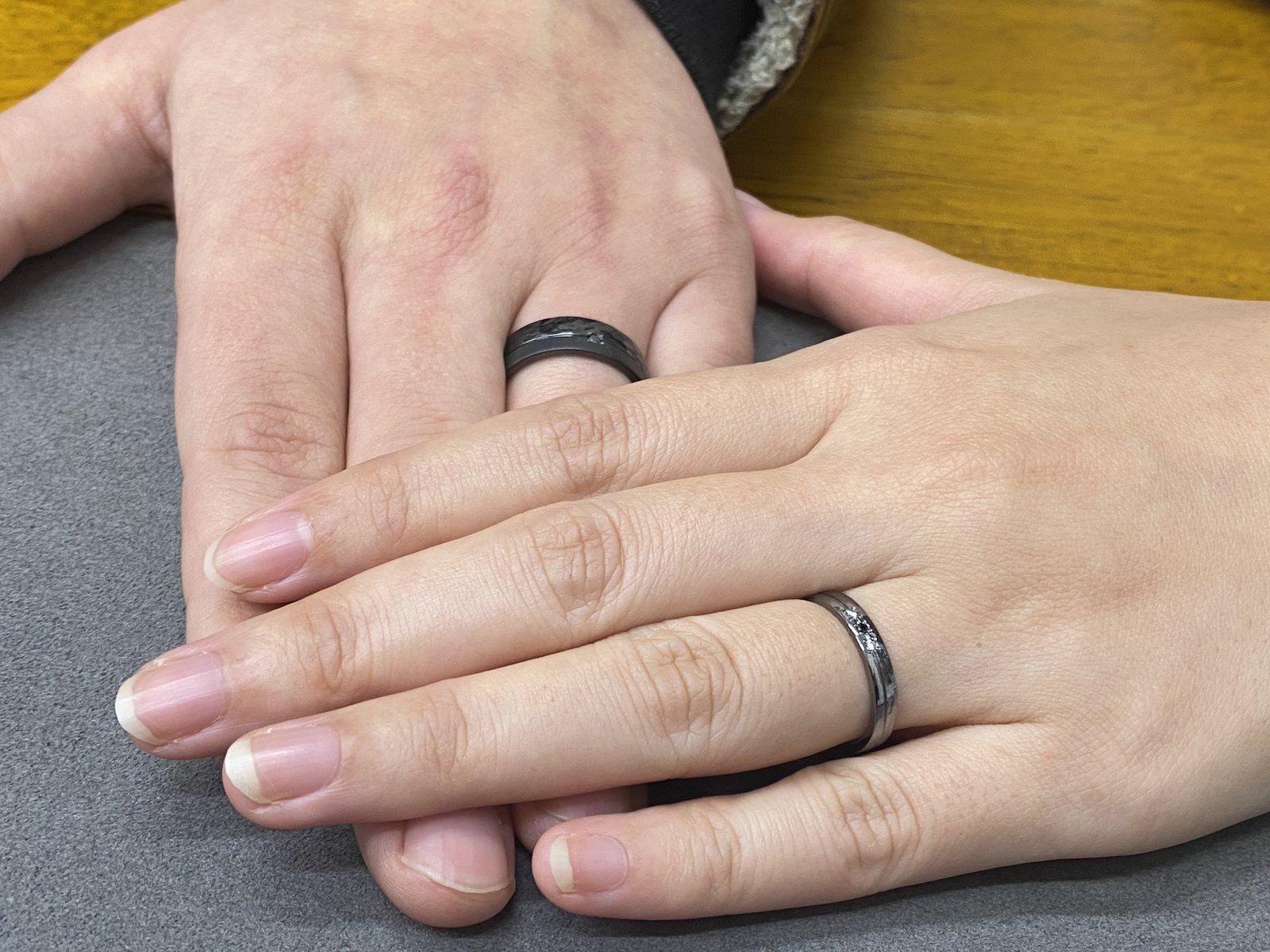 ふたりの手を重ねて黒い結婚指輪を見せた着用写真
