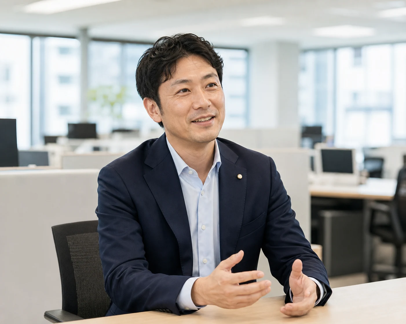 ネイビージャケットに控えめなラペルピンを合わせた30代後半の法人営業担当者