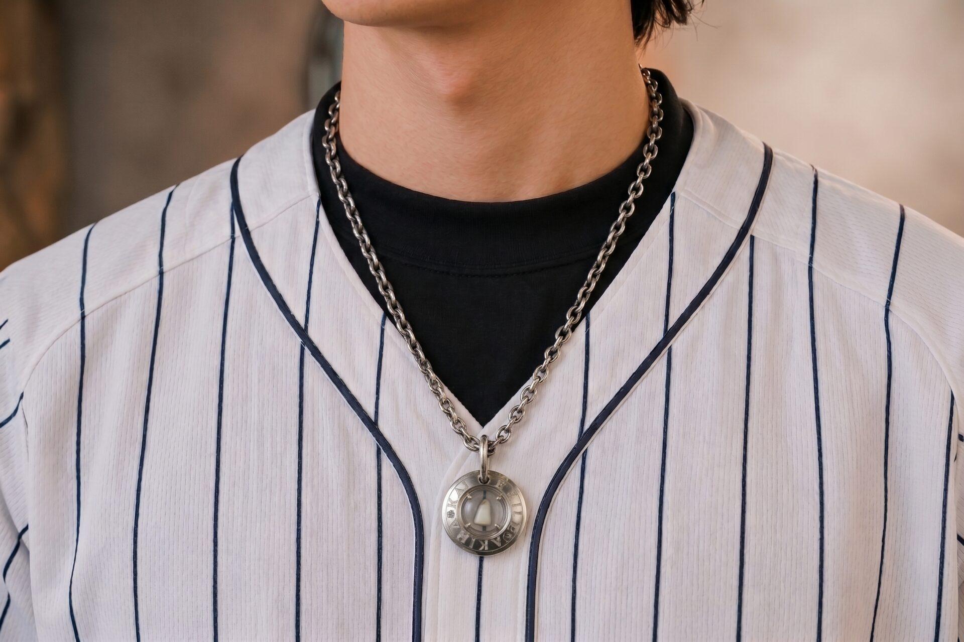 野球のユニフォーム姿で親子の絆ペンダントを着けた男性