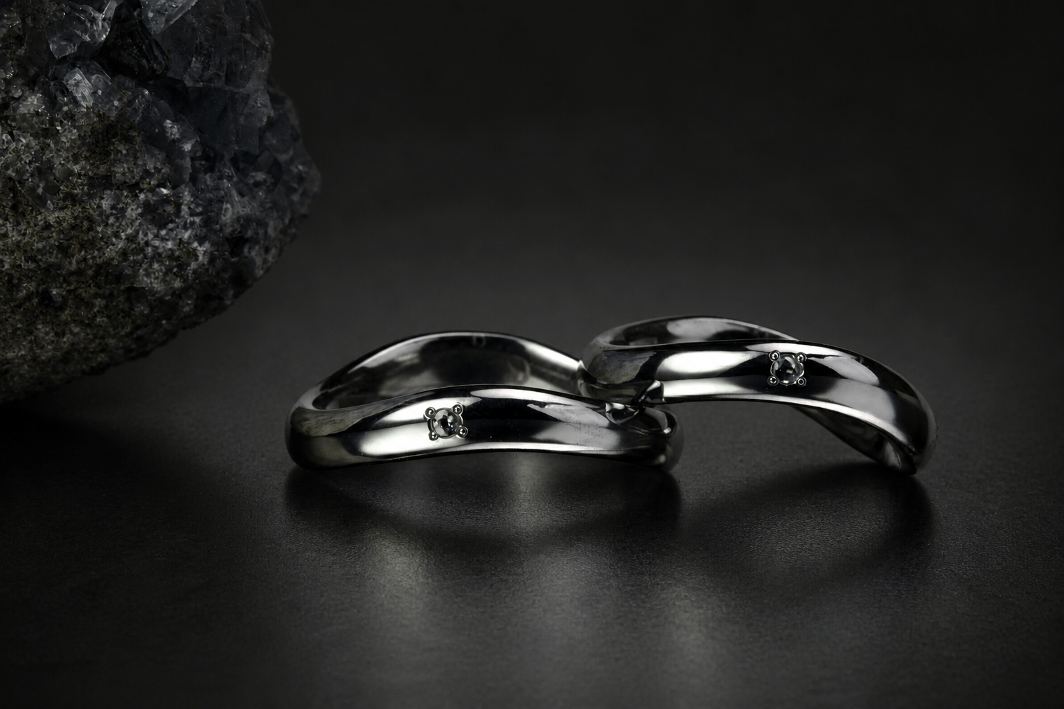 鉱物を思わせる背景に置いた石留めの結婚指輪