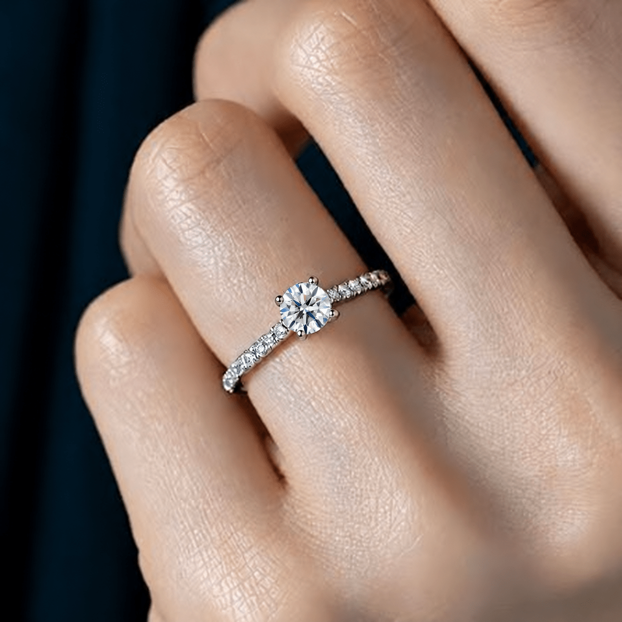 ラウンドダイヤモンドの婚約指輪を着けた女性の手元
