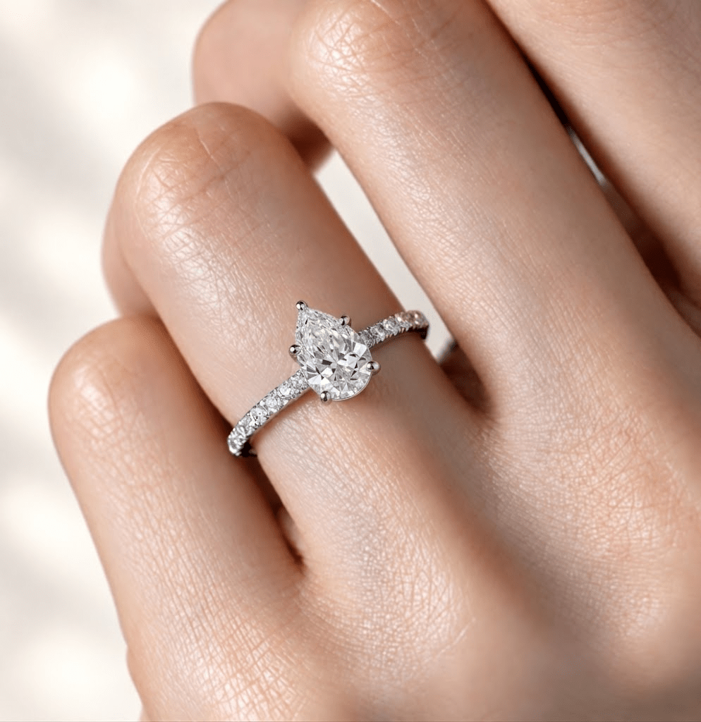 ペアシェイプの婚約指輪を着用した手