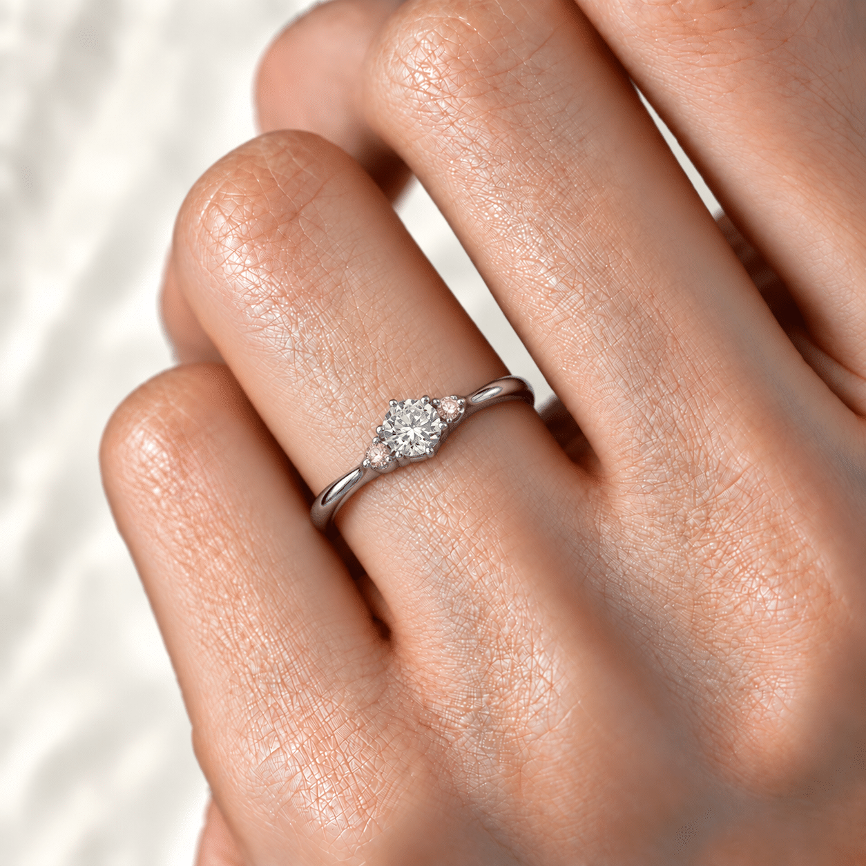 中央無色ダイヤと両脇ピンクダイヤの婚約指輪の着用イメージ